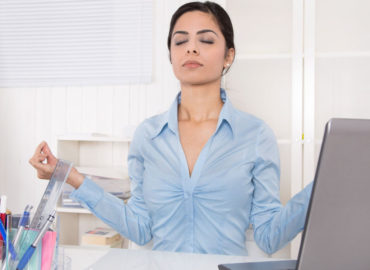 foto de mulher meditando na mesa de trabalho