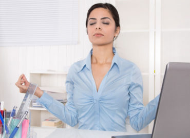 Foto de uma mulher em sua mesa de trabalho meditando