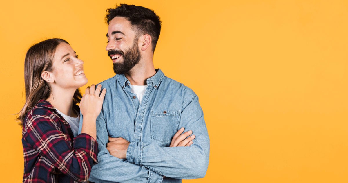 Foto de um casal se olhando, eles estão felizes e sorrindo